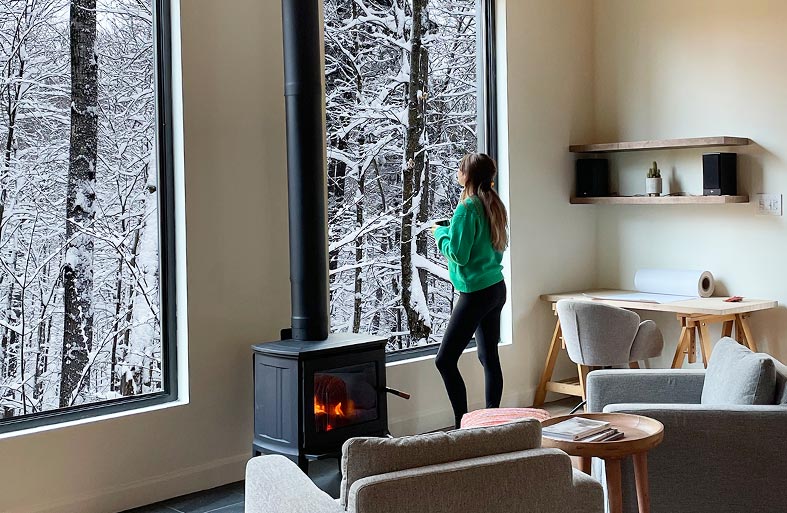 Larges fenêtres sur la forêt d'hiver chalet architectural à louer dans les laurentides