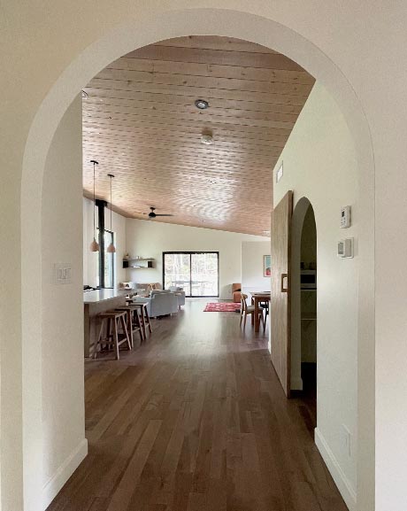 Entrée en arche vers grand espace ouvert avec vue sur la forêt, chalet à louer dans les laurentides style japandi